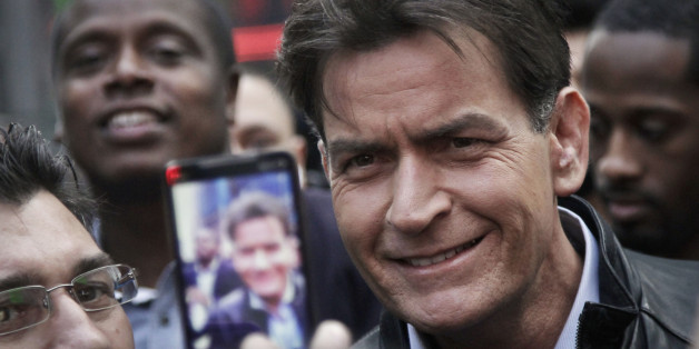 FILE - In this Monday, Jan. 14, 2013, file photo, actor Charlie Sheen is mobbed for autographs and photos as he makes his way through Times Square in New York. In an interview Tuesday, Nov. 17, 2015, on NBC's "Today," Sheen said he tested positive for the virus that causes AIDS. (AP Photo/Bebeto Matthews, File)