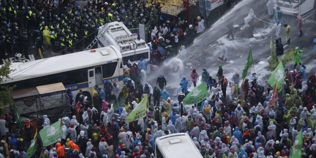 South Korean riot police officers spray water cannons as police officers try to break up protesters who tried to march to the Presidential House after a rally against government policy in Seoul, South Korea, Saturday, Nov. 14, 2015. Police fired tear gas and water cannons Saturday as they clashed with anti-government demonstrators who marched through Seoul in what was believed to be the largest protest in South Korea's capital in more than seven years.(AP Photo/Ahn Young-joon)