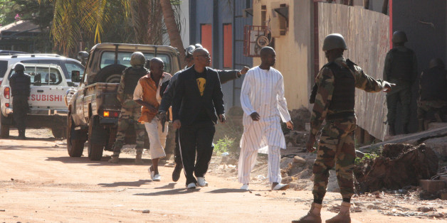 Security force personnel escort people fleeing from the Radisson Blu Hotel in Bamako, Mali, Friday, Nov. 20, 2015. The company that runs the Radisson Blu Hotel in Mali's capital says assailants have takenhostages in a brazen assault involving grenades. (AP Photo/Harouna Traore)