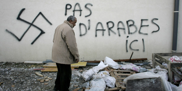 A Muslim resident stands by racial slurs painted on the walls of a mosque in the town of Saint-Etienne, central France, Monday Feb.8, 2010. The French Council of the Muslim Faith says such vandalism has multiplied in France "in a very worrisome way." The council repeated a demand for the government to create a parliamentary panel to study rising Islamophobia. Graffiti reads: No Arab here. (AP Photo/Laurent Cipriani)