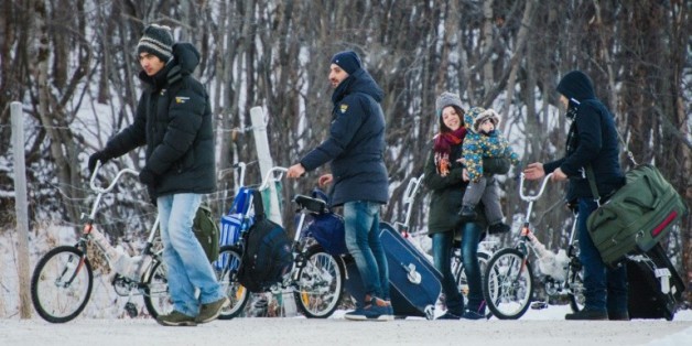 Des réfugiés en byciclette traverssent la frontière russo-norvégienne près de Kirkenes le 12 novembre 2015