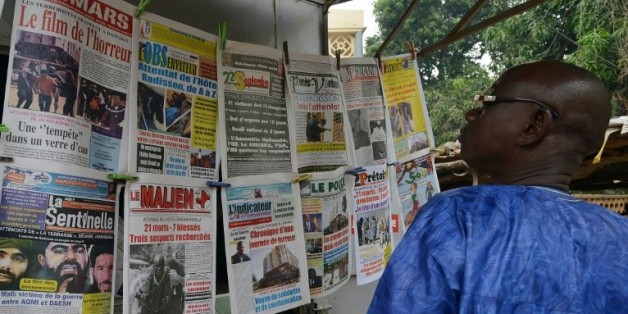 Un homme regarde les unes des journaux maliens, le 23 novembre 2015 à Bamako