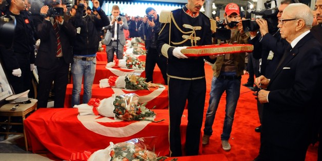 Tunisia's President Beji Caid Essebsi, right, attends a funeral ceremony held at the Presidential Palace in Carthage near Tunis, Tunisia, to honor the members of the Republican Guard killed in Tuesday's bomb blast on a bus, Wednesday, Nov. 25, 2015. Tunisian authorities said Wednesday they have discovered a 13th body in the bus attacked in central Tunis. The body is believed to be the "terrorist who caused the explosion," the Interior Ministry said. (AP Photo/Hassene Dridi)