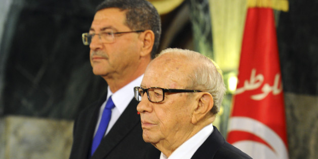 Tunisian President Beji Caid Essebsi, front and new Prime Minister Habib Essid stand at attention during a cabinet takeover ceremony in Tunis, Friday, Feb. 6, 2015. Prime Minister Essid, whose cabinet has ministers from four parties including the powerful Islamist group, promised "work and nothing but work" on the country's economic and security problems. (AP Photo/Hassene Dridi)