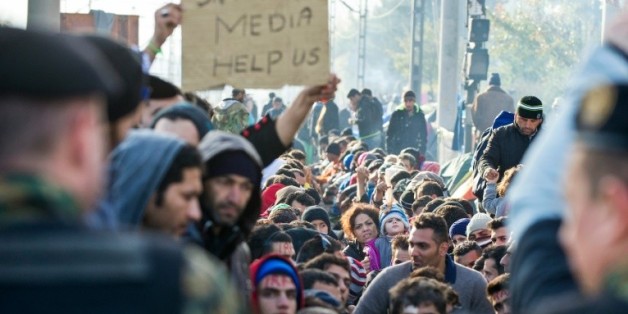 Des migrants et réfugiés, bloqués à la frontière entre la Grèce et la Macédoine, manifestent devant des policiers, le 26 novembre 2015 à Gevgelija, en Macédoine