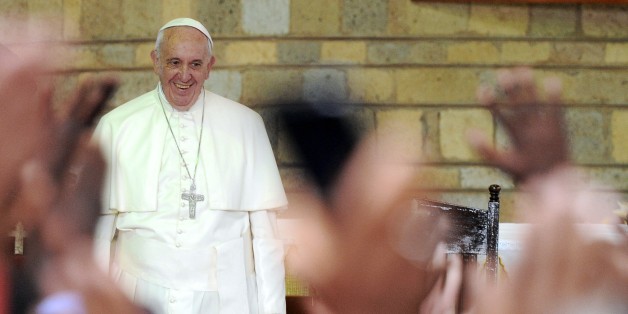 Pope Francis smiles at the Church of Saint Joseph the worker in the Nairobi shanty town of Kangemi before leading a mass on November 27, 2015 in the Kenyan capital, Nairobi. Pope Francis lashed out at wealthy minorities who hoard resources at the expense of the poor as he visited a crowded slum in the Kenyan capital. 'These are wounds inflicted by minorities who cling to power and wealth, who selfishly squander while a growing majority is forced to flee to abandoned, filthy and run-down peripheries,' the 78-year-old pontiff told crowds in the Nairobi shanty town of Kangemi. AFP PHOTO / Tony KARUMBA / AFP / TONY KARUMBA (Photo credit should read TONY KARUMBA/AFP/Getty Images)