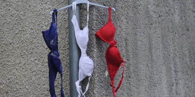 Bras in the colors of the French national flag hang from a house's gutter in La Rochelle, southwestern France, on NOvember 27, 2015 during a day of national tribute to the 130 people killed in the November 13 Paris attacks. AFP PHOTO / XAVIER LEOTY / AFP / XAVIER LEOTY (Photo credit should read XAVIER LEOTY/AFP/Getty Images)