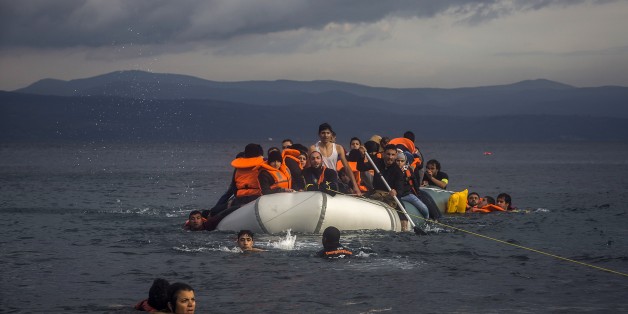 Volunteers help refugees to approach the coast after engine problems on their dinghy in the northeastern Greek island of Lesbos Wednesday, Nov. 25, 2015. About 5,000 migrants reaching Europe each day over the so-called Balkan migrant route. The refugee crisis is stoking tensions among the countries on the so-called Balkan migrant corridor â Greece, Macedonia, Serbia, Croatia and Slovenia. (AP Photo/Santi Palacios)