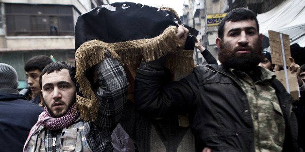 Syrian rebels carry the body of a fallen comrade in Aleppo, Syria, Friday, Dec. 21, 2012.(AP Photo/Virginie Nguyen Hoang)