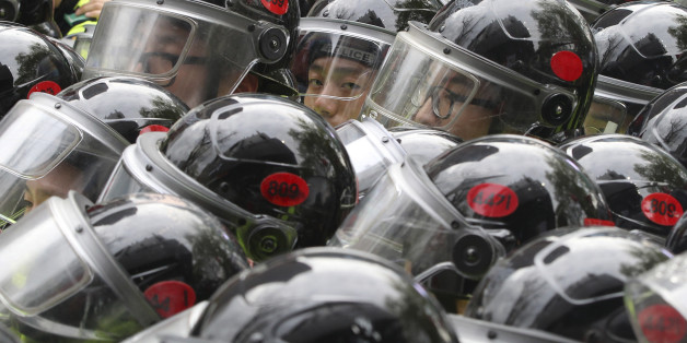 Police officers stand to block protestors trying to march toward presidential house after a rally to commemorate the first anniversary of the Sewol ferry sinking in Seoul, South Korea, Saturday, April 18, 2015. About 10,000 protesters called on the government to salvage the ferry off the country's southwest coast and demanded the discard of South Korean government's enforcement ordinance which plans for a smaller investigation committee than what had been proposed by the victims' families and al