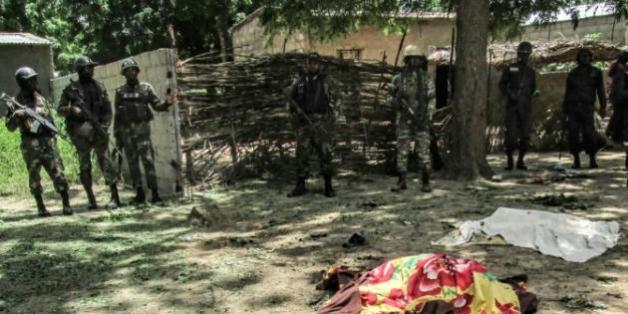 Des membres de la sécurité camerounaise devant la dépouille d'une victime d'un attentat suicide à Kolofata, dans l'extrême nord du Cameroun, le 13 septembre 2015
