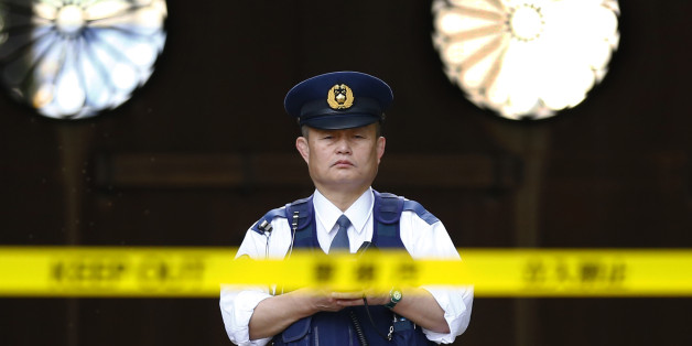 In this Tuesday, Nov. 24, 2015, file photo, a police officer stands guard in front of the south gate of Yasukuni shrine in Tokyo. An explosion on Monday damaged a public restroom at a controversial shrine in Tokyo that honors Japanese war dead, with police suspecting foul play. No one was injured. (AP Photo/Shizuo Kambayashi, File)