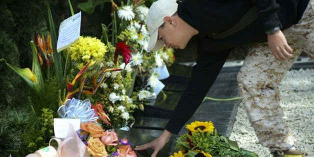 Un touriste fleurit la tombe de Pablo Escobar à Medellin le 2 décembre 2015
