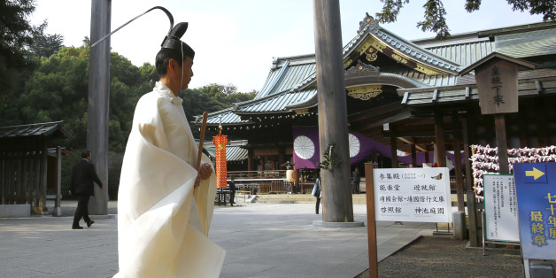 A Shinto priest walks in front of the main shrine during the four-day annual Autumn Festival in the compound of Yasukuni Shrine in Tokyo, Tuesday, Oct. 20, 2015. The shrine honors Japan's war dead, including convicted World War II leaders. (AP Photo/Shizuo Kambayashi)