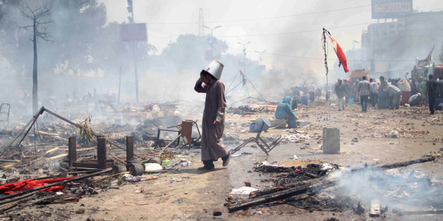 A supporter of Egypt's ousted president Mohamed Morsi walks through the debris following clashes with police in Cairo on August 14, 2013, as security forces backed by bulldozers moved in on two huge pro-Morsi protest camps, launching a long-threatened crackdown that left dozens dead. The clearance operation began shortly after dawn when security forces surrounded the sprawling Rabaa al-Adawiya camp in east Cairo and a similar one at Al-Nahda square, in the centre of the capital. AFP PHOTO / MOS