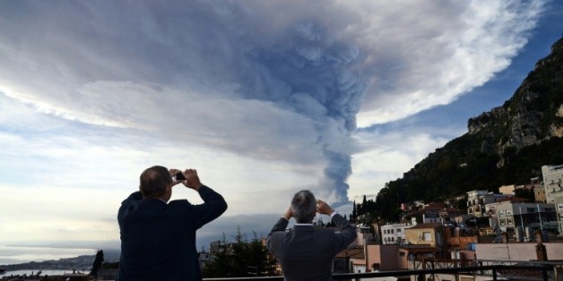 Des badauds prennent des photos de l'Etna en éruption, le 4 décembre 2015 à Taormina en Sicile