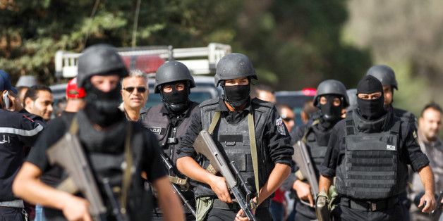 Members of the Tunisian National Guard take positions as they secure the scene of a shooting in the Oued Ellil suburb of Tunis, Tunisia, Thursday, Oct. 23, 2014. A Tunisia official says a security officer has been killed in a shootout that began when a suspect's home was surrounded near the capital. Interior Ministry spokesman Mohammed Ali Aroui says the exchange of fire Thursday came after a pair of counterterrorism operations in the south that left one bystander dead. (AP Photo/Aimen Zine)