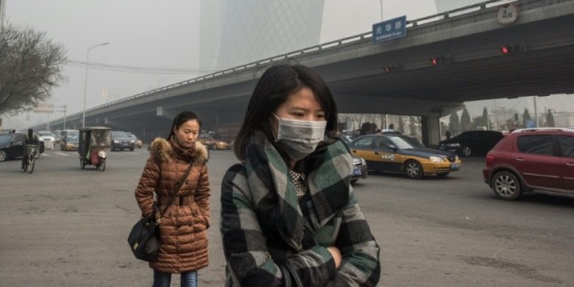Une femme porte un masque pour se protéger de la pollution le 30 novembre 2015 à Pékin
