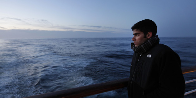 A passenger of MS Balmoral Titanic memorial cruise ship, gazes out to the Atlantic Ocean, following a memorial service, marking the 100-year anniversary of the Titanic disaster, in the early hours of Sunday, April 15, 2012. The Titanic passenger liner was built in Belfast, and sank in the North Atlantic Ocean on its maiden voyage from England to New York, USA, in the early hours of April 15, 1912, after colliding with an iceberg and over 1,500 people perished in the sinking. (AP Photo/Lefteris Pitarakis)