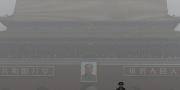 A Chinese paramilitary policeman stands on duty near Tiananmen Gate shrouded with heavy pollution and fog in Beijing, Tuesday, Dec. 1, 2015. Schools in the Chinese capital kept students indoors and parents brought their kids to hospitals with breathing ailments Tuesday as Beijing grappled with extremely severe air pollution for the fifth straight day. (AP Photo/Andy Wong)
