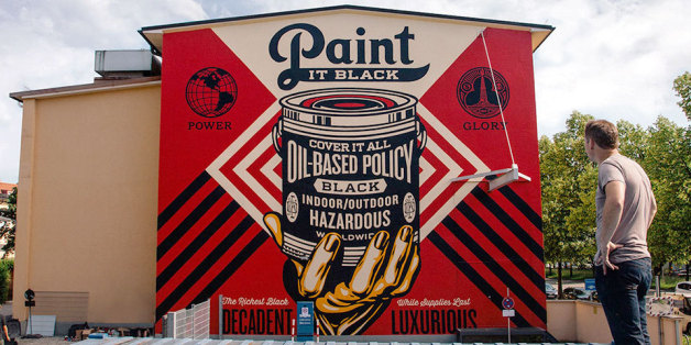 Shepard Fairey vor seinem 15 x 13 Meter großen Mural, in dem er die von international agierenden Ölkonzernen ausgehende Beeinflussung der Weltpolitik thematisiert. Er will vor einer dauerhaften Zerstörung von Natur und Umwelt warnen.