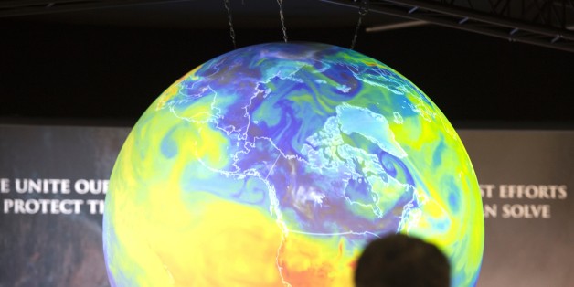People watch the Earth globe at the COP21, the United Nations conference on climate change in Le Bourget on December 10, 2015. Weary ministers tasked with rescuing mankind from catastrophic climate change struggled on December 10 to overcome a rich-poor divide, with little more than 24 hours left to reach a deal. / AFP / MIGUEL MEDINA (Photo credit should read MIGUEL MEDINA/AFP/Getty Images)