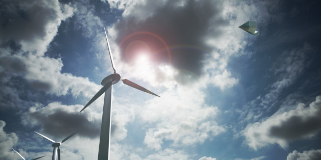 Paper airplane flying above the wind farms