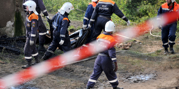 Rescuers carry a body bag with a victim of a fire near the charring remains of a burned out psychiatric hospital in the village of Luka in the northwest Russian Novgorod region on September 13, 2013. Thirty seven people were killed when a fire swept through a wooden psychiatric hospital in northwest Russia overnight yesterday, regional investigators said. AFP PHOTO / OLGA MALTSEVA (Photo credit should read OLGA MALTSEVA/AFP/Getty Images)