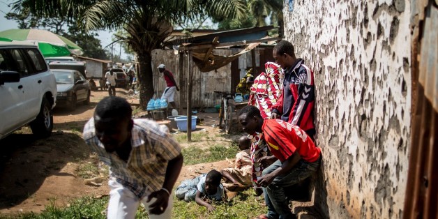 Des hommes se mettent à l'abri pendant que des tirs à l'arme lourde retentissent à Bangui, le 13 décembre 2015