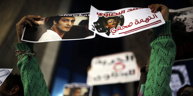 An Egyptian journalist holds posters calling for the release of photojournalists Mohammad al-Batawi, right, and Mahmoud Abou-Zeid, known as Shawkan, in front of the Syndicate of Journalists building in Cairo, Egypt, Wednesday, Dec. 9, 2015. Shawkan was arrested in August 2013 while taking photographs of the governmentâs violent dispersal of a sit-in by supporters of ousted Islamist President Mohammed Morsi and has spent over 800 days locked up without charges. (AP Photo/Amr Nabil)