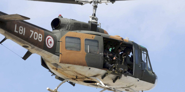 A Tunisian army helicopter flies over the Bardo museum, Wednesday, March 18, 2015 in Tunis, after gunmen opened fire at the Bardo museum in Tunisia's capital. Authorities say scores of people are dead after an attack on a major museum in the Tunisian capital, and some of the gunmen may have escaped. (AP Photo/Ali Ben Salah)