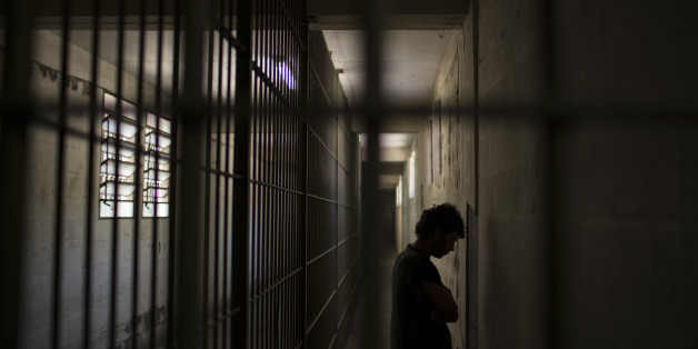 In this Nov. 30, 2015 photo, an inmate stands facing the wall as he waits for authorization to walk to his cell inside the Central Prison in Porto Alegre, Brazil. As with many nations in Latin America, the penitentiary system is chaotic and cruel, with violent uprisings across Brazil breaking out frequently as prisoners rebel against horrific conditions. (AP Photo/Felipe Dana)