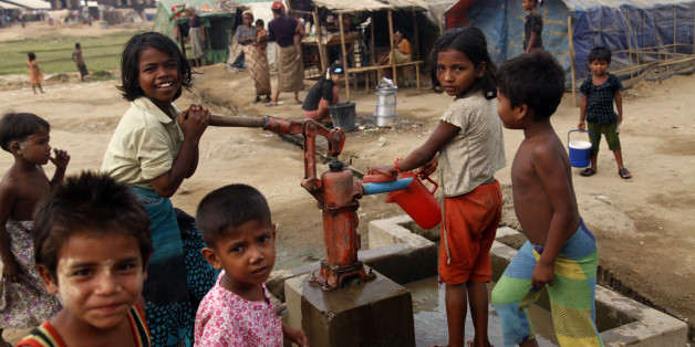 In this photo taken on April 2, 2014, Muslim refugee children gather at a tube-well to fetch water near their tents at Da Paing camp in north of Sittwe, Rakhine State, western Myanmar. Myanmar vowed Wednesday to protect U.N. and humanitarian aid workers seeking to return to the strife-torn state of Rakhine after rampaging Buddhist mobs attacked the workers' homes and offices. (AP Photo/Khin Maung Win)
