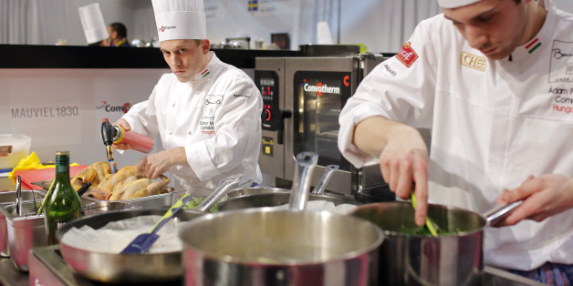 Gabor Molnar of Hungary, left, prepares food with his assistant Adam Pohner, right, during the "Bocuse d'Or" (Golden Bocuse) trophy, at the 15th World Cuisine contest, in Lyon, central France, Wednesday, Jan. 28, 2015. The contest, a sort of world cup of the cuisine, was started in 1987 by Lyon chef Paul Bocuse to reward young international culinary talents. (AP Photo/Laurent Cipriani)