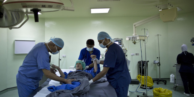 In this Monday, Aug. 17, 2015 photo, Syrian girl Salam Rashid, 14, is prepared for surgery at MSF Hospital for Specialized Reconstructive Surgery, run by the international charity Médecins Sans Frontières (Doctors Without Borders) in Amman, Jordan. Three years ago, her lower legs were blown off by a tank shell outside her home in Khirbet Ghazaleh in southern Syria. Her older sister Thaleq, who was with her at the time, was killed. Salam now walks on padded stumps that end below her knees.(AP Photo/Muhammed Muheisen)