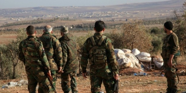 Des forces syriennes pro-gouvernement surveillent une zone près du village de Khan Tuman dans la province d'Alep, le 22 décembre 2015