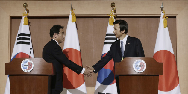 South Korean Foreign Minister Yun Byung-se, right, shakes hands with his Japanese counterpart Fumio Kishida after their joint press conference at Foreign Ministry in Seoul, South Korea, Monday, Dec. 28, 2015. The foreign ministers said they had reached a deal meant to resolve a decades-long impasse over Korean women forced into Japanese military-run brothels during World War II, a potentially dramatic breakthrough between the Northeast Asian neighbors and rivals. (AP Photo/Ahn Young-joon)
