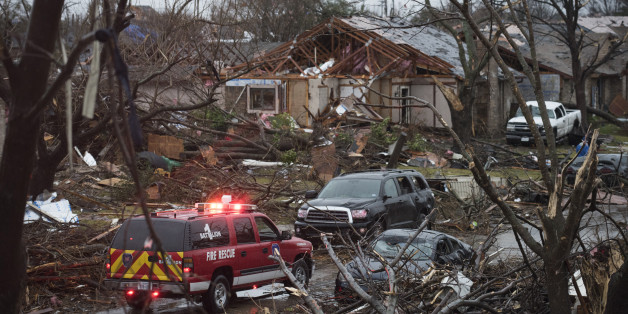 An emergency vehicle drives through a neighborhood in Rowlett, Texas, Sunday, Dec. 27, 2015, the morning after it was struck by a tornado. At least 11 people died and dozens were injured in apparently strong tornadoes that swept through the Dallas area and caused substantial damage this weekend. (AP Photo/Rex C. Curry)