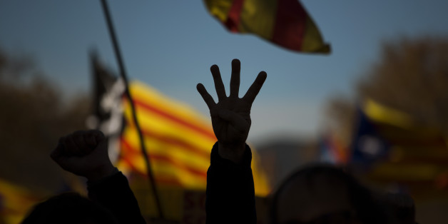 A pro Independence demonstrator gestures - four fingers symbolizing the four bars of the Catalonian flag, during a demonstrations to show public support for the Parliament of Catalonia, in Barcelona, Spain, Sunday, Nov. 22, 2015. Prime Minister Mariano Rajoy made his first visit to the regional capital of Catalonia on Saturday following his administration's legal push to halt an effort secessionist regional parties to declare independence from Spain by 2017. (AP Photo/Emilio Morenatti)