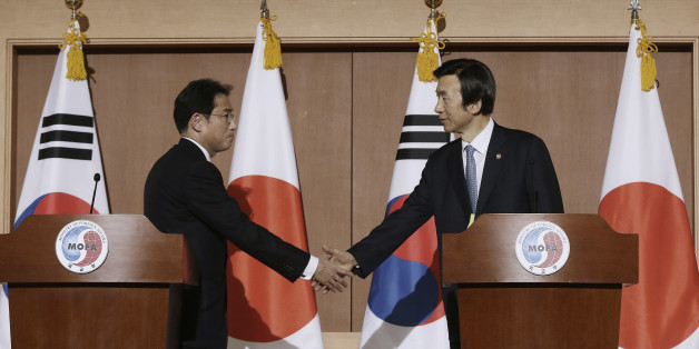 South Korean Foreign Minister Yun Byung-se, right, shakes hands with his Japanese counterpart Fumio Kishida after their joint press conference at Foreign Ministry in Seoul, South Korea, Monday, Dec. 28, 2015. The foreign ministers said they had reached a deal meant to resolve a decades-long impasse over Korean women forced into Japanese military-run brothels during World War II, a potentially dramatic breakthrough between the Northeast Asian neighbors and rivals. (AP Photo/Ahn Young-joon)