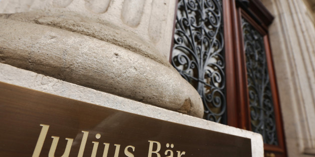 A sign sits by the entrance to Bank Julius Baer & Company Ltd. in Geneva, Switzerland, on Friday, Oct. 16, 2015. Once bastions of secrecy, 41 Swiss banks signed amnesty agreements this year with the U.S. Justice Department that required disclosing the tricks they used to help customers hide assets, naming bankers and middlemen who enabled them and detailing the flow of untaxed money. Photographer: Luke MacGregor/Bloomberg via Getty Images