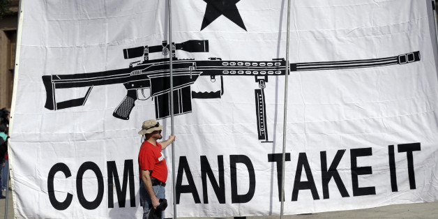 FILE - In this Jan. 26, 2015 file photo, a demonstrator helps hold a large "Come and Take It" banner at a rally in support of open carry gun laws at the Capitol, in Austin, Texas. Texas, the second-most populous state, is joining 44 other states in allowing at least some firearm owners to carry handguns openly in public places. Under the Texas law, guns can be carried by those with licenses and only in holsters. (AP Photo/Eric Gay, File)