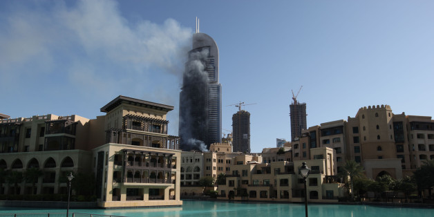 Smoke billows from the Address Downtown skyscraper in Dubai, United Arab Emirates on Friday, Jan. 1, 2016. The blaze began Thursday night before Dubai's annual New Year's Eve fireworks show at the Burj Khalifa, the world's tallest building which sits nearby. (AP Photo/Jon Gambrell)