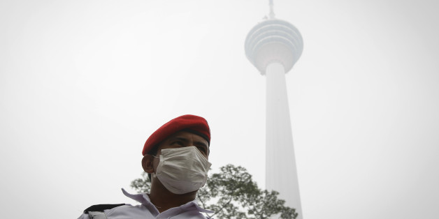 A security man stands guard in front of the Kuala Lumpur Tower shrouded by haze in Kuala Lumpur, Malaysia Monday, Sept. 14, 2015. On Monday unhealthy API (Air Pollutant Index) readings were recorded at 30 locations nationwide as persistent haze from Indonesian forest fires worsened. (AP Photo/Joshua Paul)