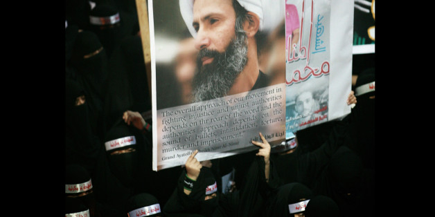 FILE - In this Sunday, Sept. 30, 2012 file photo, a Saudi anti-government protester carries a poster with the image of jailed Shiite cleric Sheik Nimr al-Nimr during the funeral of three Shiite Muslims allegedly killed by Saudi security forces in the eastern town of al-Awamiya, Saudi Arabia. A court in Saudi Arabia has postponed issuing a verdict in a sensitive case against a popular Shiite cleric who faces charges that carry the death sentence. Al-Nimrâs brother Mohammed al-Nimr told The Associated Press that the verdict was delayed until Oct. 21. (AP Photo, File)