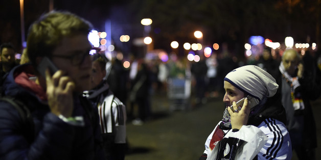 HANOVER, GERMANY - NOVEMBER 17: People speak on their mobile phone shortly after the match between Germany and the Netherlands was cancelled following a bomb alert at the HDI-Arena on November 17, 2015 in Hanover, Germany. The Match was cancelled after unoffical sources said there was a bomb inside a car at the parking area at the front gate. Special Forces from other cities are expected to arrive shortly at the scene. The German Federal Police raised the number of heavily armed police officers inside the main train station and airport at Hanover and at the HDI-Arena, in order to increase security after the attacks in Paris last week. German chancellor Angela Merkel and members of the German Federal cabinet were expected to be among the guests at the match. (Photo by Alexander Koerner/Getty Images)