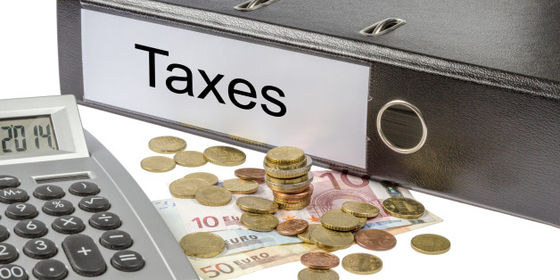 A Binder labeled wit the word Taxes, calculator and european currency isolated on white background