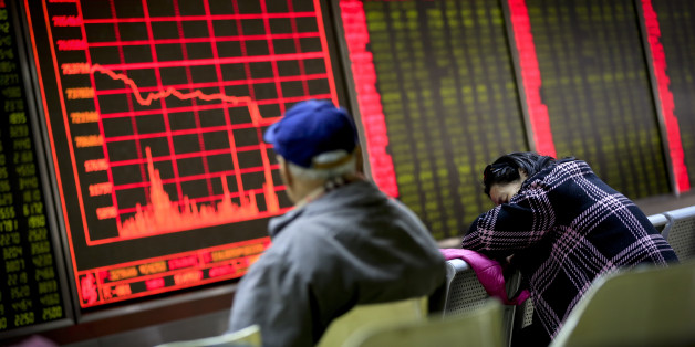 A woman takes a nap as a man looks at an electronic board displaying stock prices at a brokerage house in Beijing, Monday, Jan. 4, 2016. Shanghai's stock index plunged nearly 7 percent on Monday, sparking a halt in trading of Chinese shares, after weak manufacturing data and Middle East tensions weighed on Asian markets. (AP Photo/Andy Wong)