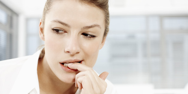 Businesswoman biting fingernails