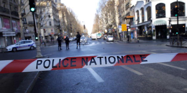 Police officers cordon off the area of a fatal shooting which took place at a police station in Paris, Thursday, Jan. 7, 2016. Officers shot and killed a knife-wielding man with wires protruding from his clothes at a police station in northern Paris on Thursday, French officials said, a year to the day after an attack on the French satirical newspaper Charlie Hebdo launched a bloody year in the French capital. (AP Photo/Christophe Ena)
